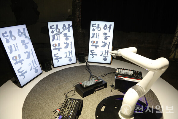 [천지일보=백은영 기자] ‘기획향(조영각, 혼합매체 2025)’. 로봇이 인공지능에게 명령하는 장면을 통해 ‘수행’의 개념을 인간과 기계의 경계에서 재정의한다. 로봇은 붓으로 키보드와 패드를 눌러 생성형 인공지능에 움직임을 입력한다. 그리고 인공지능은 문자도를 닮은 이미지를 실시간으로 만들어낸다. 한글과 첨단 기술의 융합을 통해 새로운 창작자의 정체성과 미래 창작 환경의 일부분을 보여준다. ⓒ천지일보 2025.11.19.