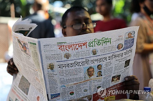 18일 다카에서 한 시민이 지난해 축출된 셰이크 하시나 전 총리에게 사형 판결이 내려졌다는 제목이 실린 신문을 보고 있다. (출처: 연합뉴스)