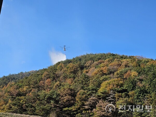 [천지일보 순천=최수아 기자] 21일 오전 전남 순천시 서면 동산리 인근 야산에서 발생한 산불 진화 현장. 헬기가 산 정상 부근에서 물을 살포하며 불길을 잡고 있다. ⓒ천지일보 2025.11.21.