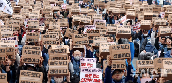 23일 오후 서울 종로구 동십자각 앞에서 열린 '과로사 없는 택배 만들기 시민대행진'에서 택배 노조원들이 구호를 외치고 있다. (출처: 뉴시스)