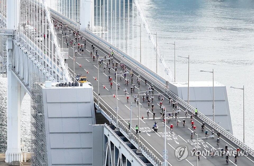 (부산=연합뉴스) 21일 오전 '2025 세븐브릿지 투어'에 참가자들이 부산 광안대교 위를 달리고 있다.