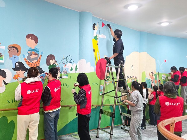 LG유플러스는 충북 충주시 충주성모학교에 시각장애 학생들의 독서와 교육을 돕기 위한 'U+희망도서관'을 구축했다. 사진은 LG유플러스 임직원들이 충주성모학교 담장에 벽화를 그리는 모습. (제공: LG유플러스)