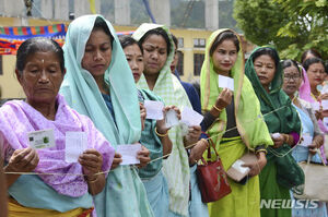 19일(현지시간) 인도 마니푸르주 임팔 외곽 미슈누푸르 선거구에서 주민들이 투표를 하기 위해 서서 신분증과 투표 용지를 보여주고 있다. 이번 총선에서는 약 9억 7천만명의 유권자가 6월 1일까지 진행되는 선거를 통해 5년 임기의 하원의원 543명을 선출하게 된다. (출처: 뉴시스)