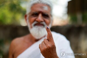 (티루반나말라이[인도] 로이터=연합뉴스) 19일 인도 타밀나두주 티루반나말라이의 한 투표소에서 힌두교 성직자가 투표를 마친 후 특수 잉크가 묻은 손가락을 보이고 있다. 인도는 중복 투표를 막기 위해 기표한 유권자의 손가락에 한동안 지워지지 않는 잉크를 묻힌다.